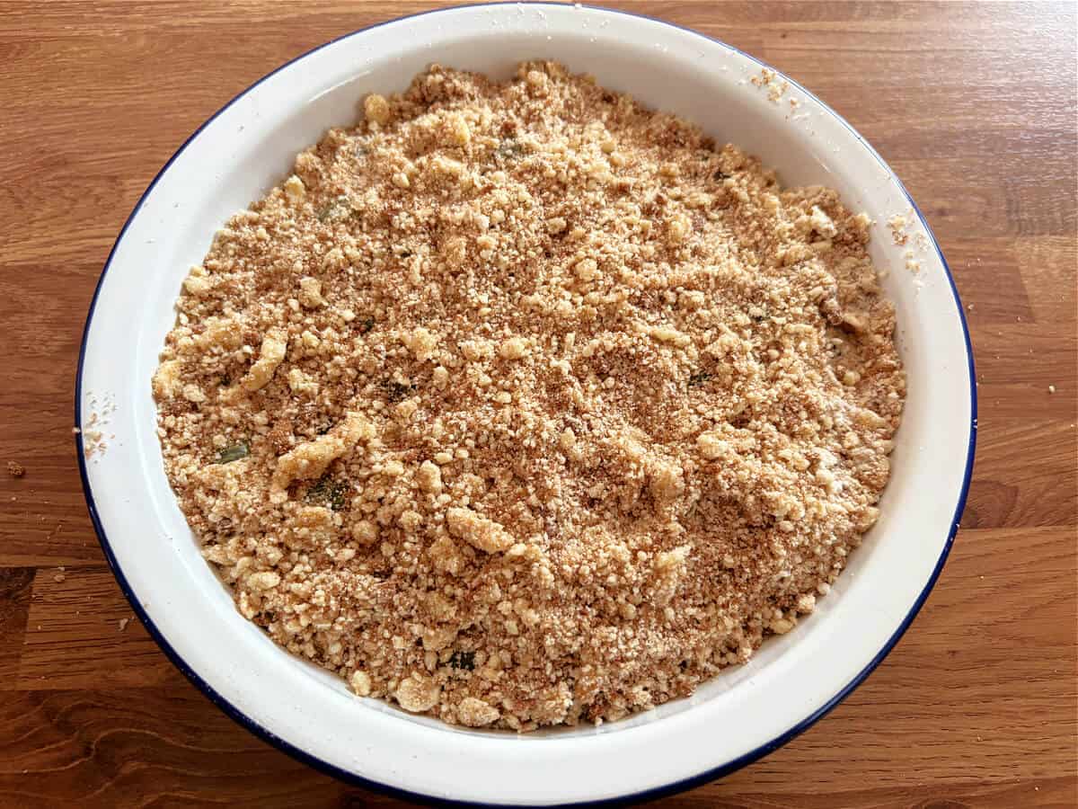 Assembled gooseberry crumble in pie dish, before baking.