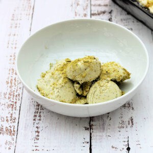 Scoops of pistachio ice cream in a white bowl.