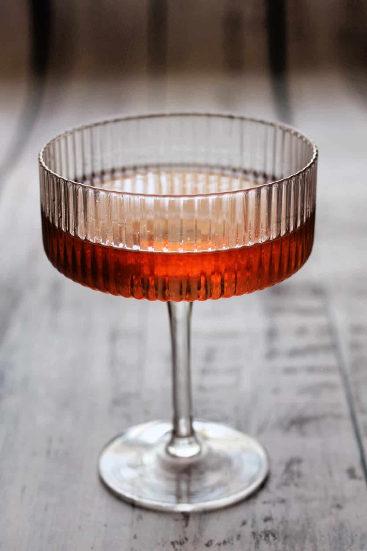 Red gin cocktail in a cocktail glass.