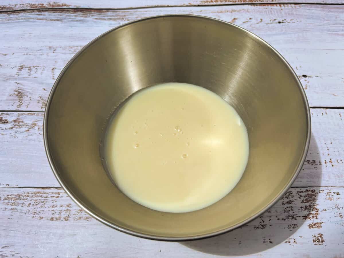 Condensed milk in a metal bowl.