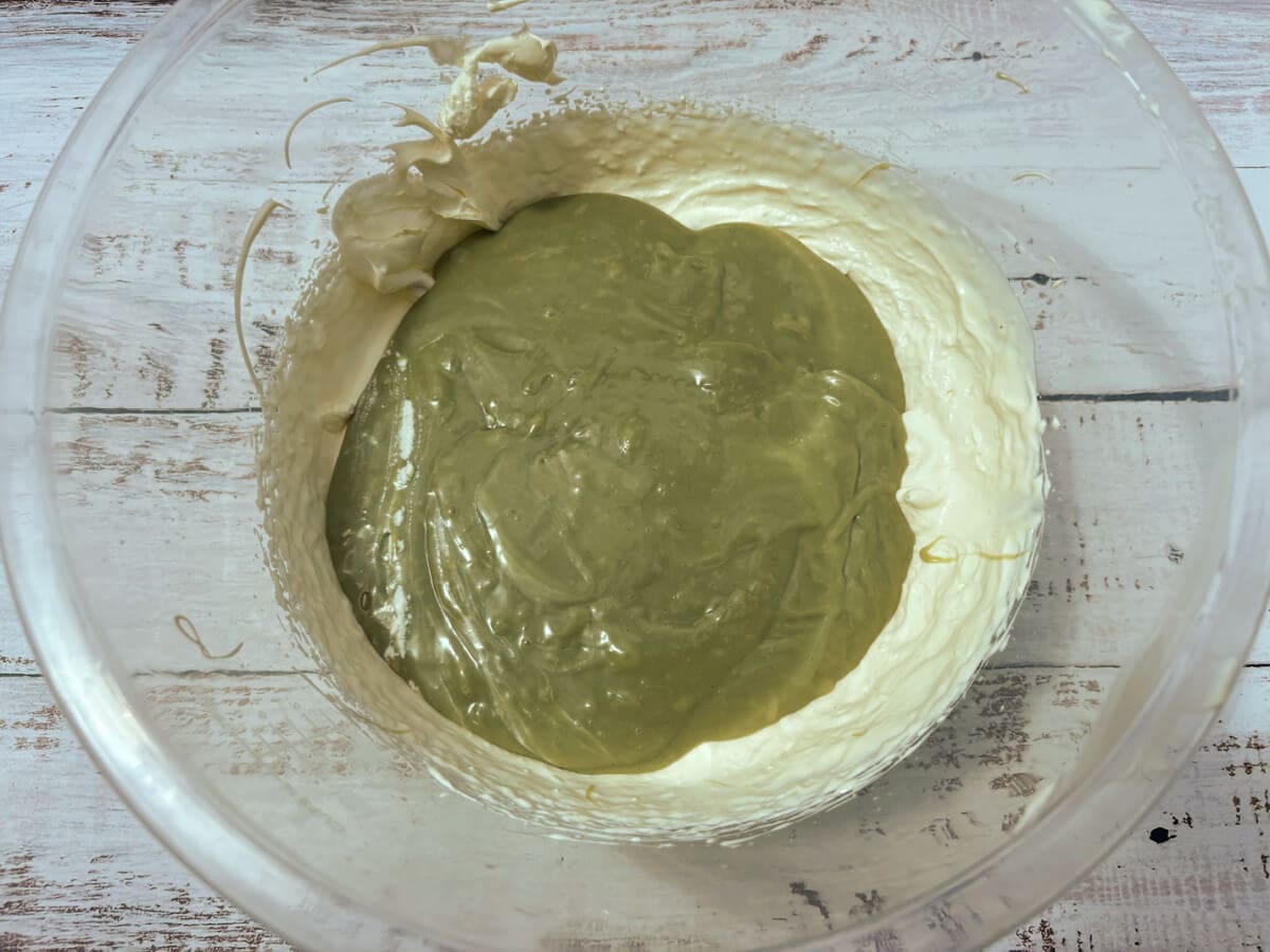 Whipped cream and pistachio mixture in a clear bowl.