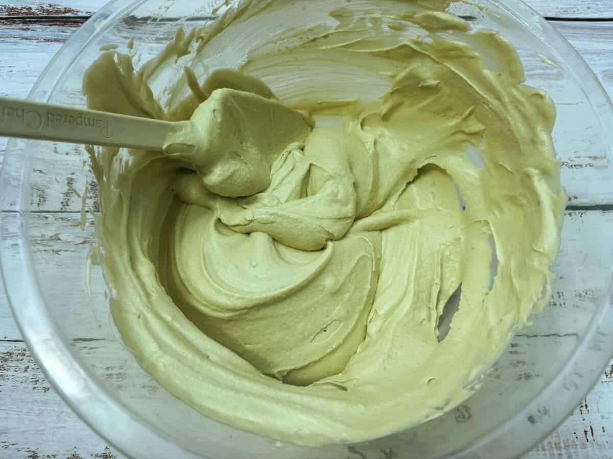 Pistachio ice cream base in a clear bowl.