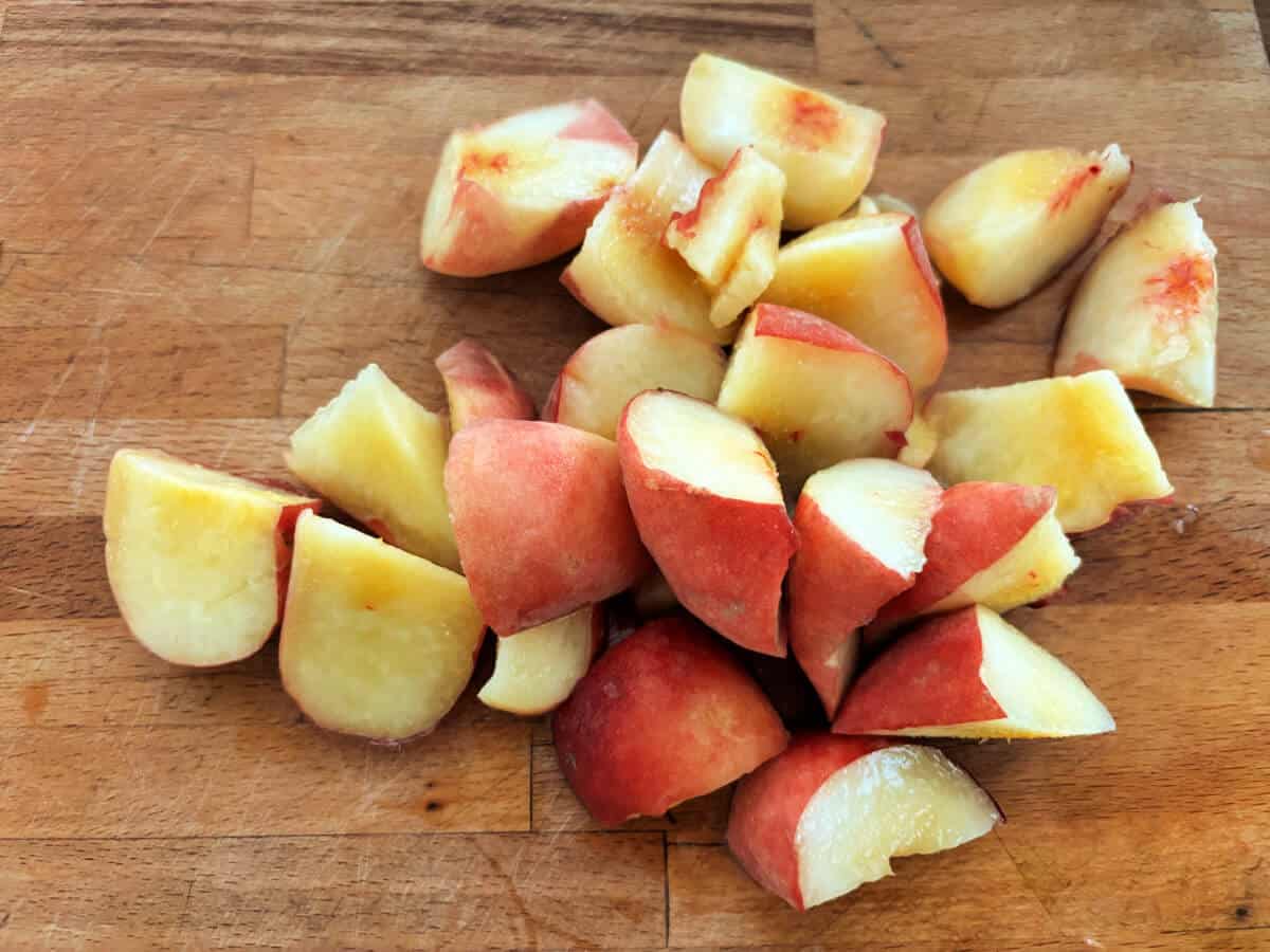 Chopped peaches on a wooden board.