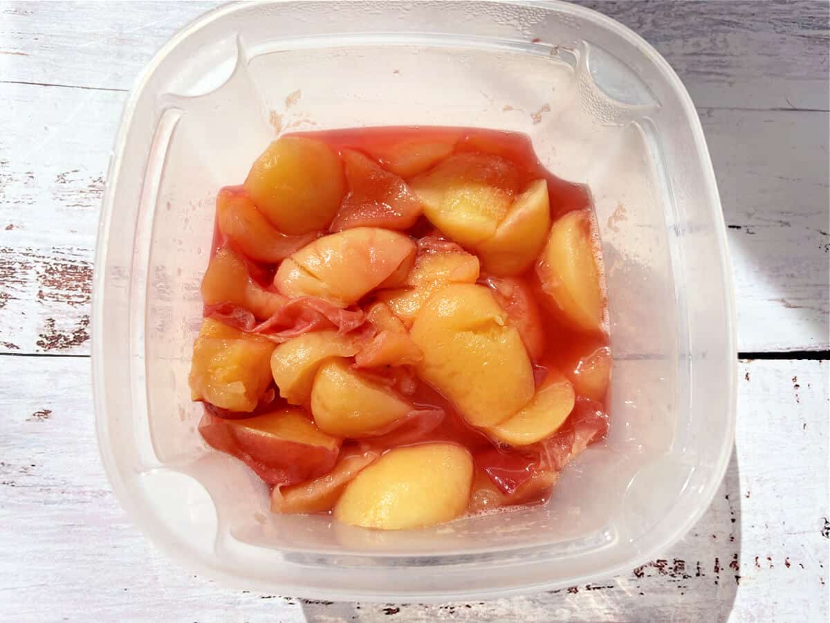 Peaches in juice in a tub.