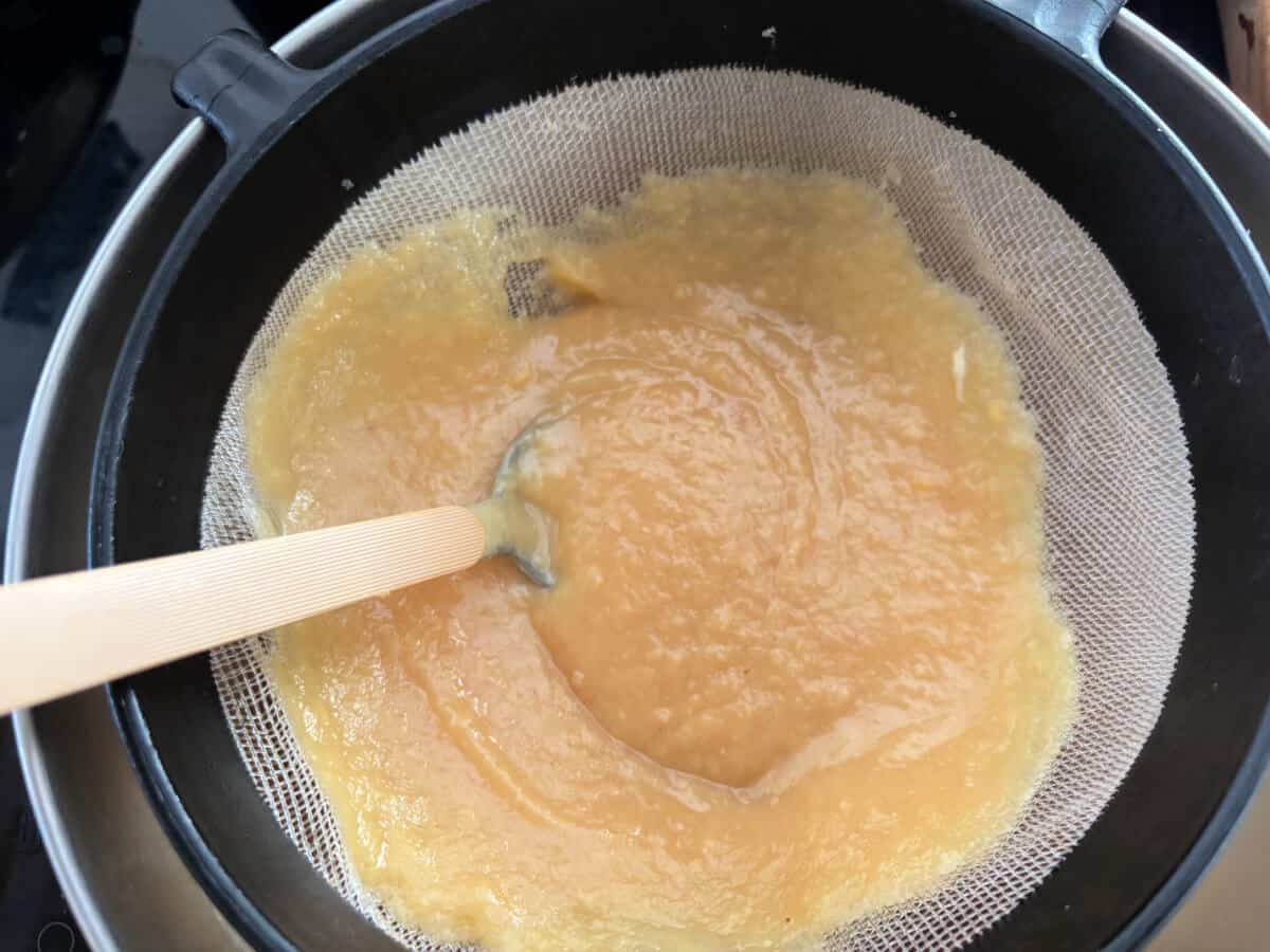 Curd being strained through a sieve.