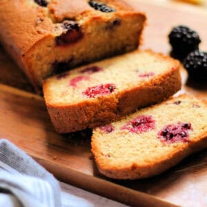 Slices of blackberry cake on a wooden board.