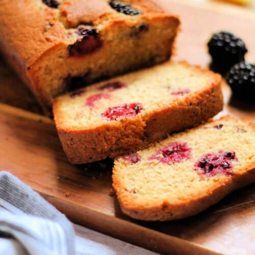 Slices of blackberry cake on a wooden board.