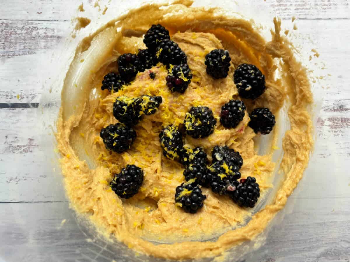 Cake mixture with blackberries and lemon zest added.