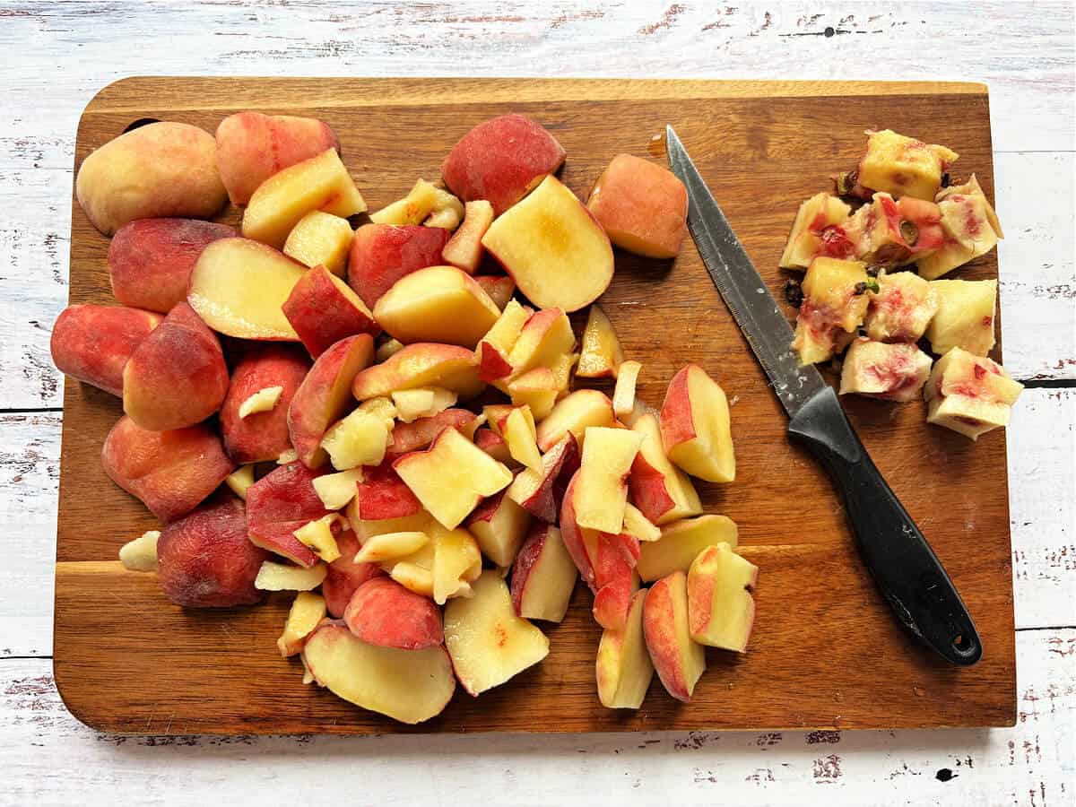Chopped peaches on a wooden board.