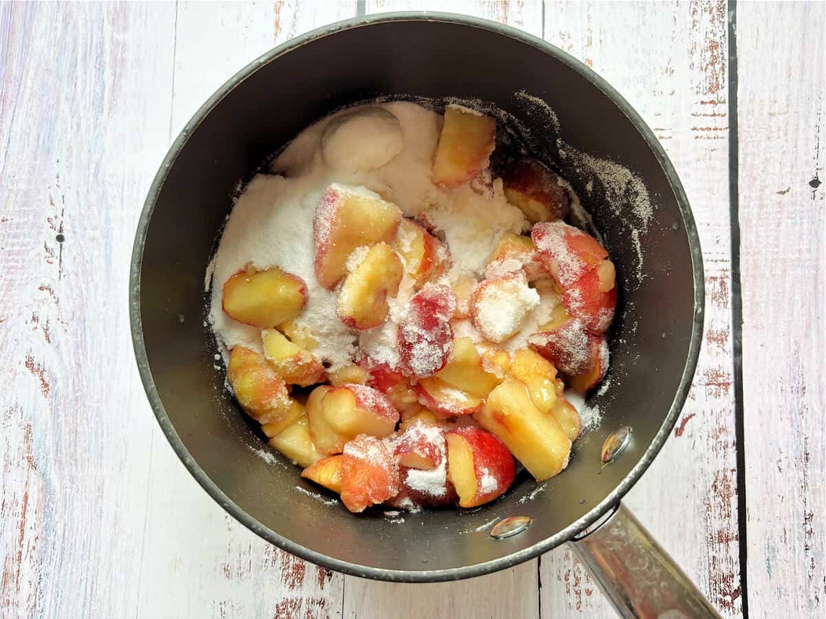 Peaches and sugar in a pan.