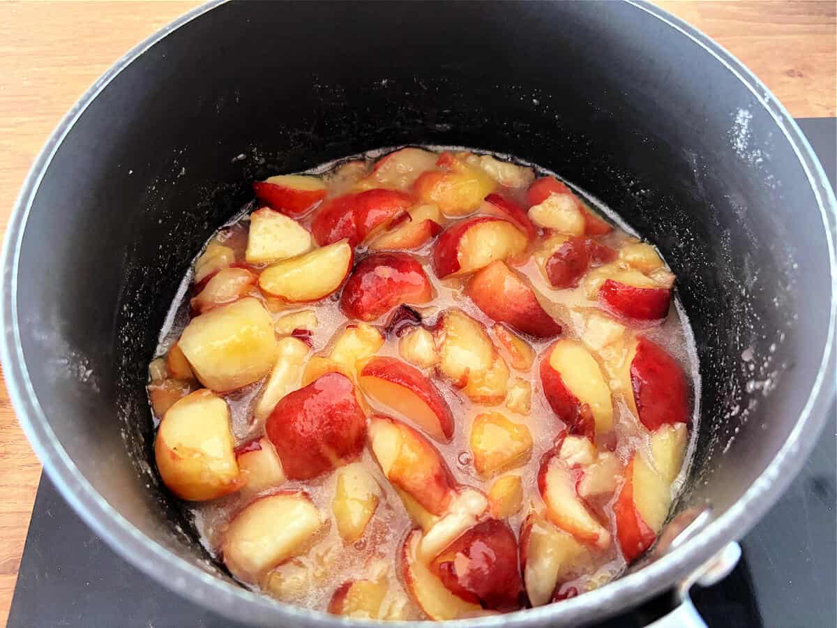 Peaches cooking in a pan.
