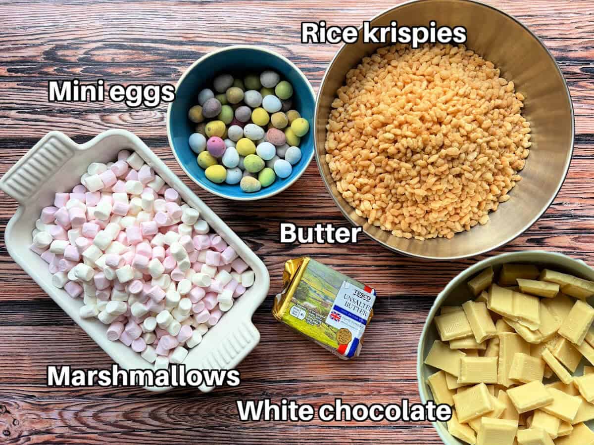 Labelled ingredients for mini egg Rice Krispie treats on wooden surface.