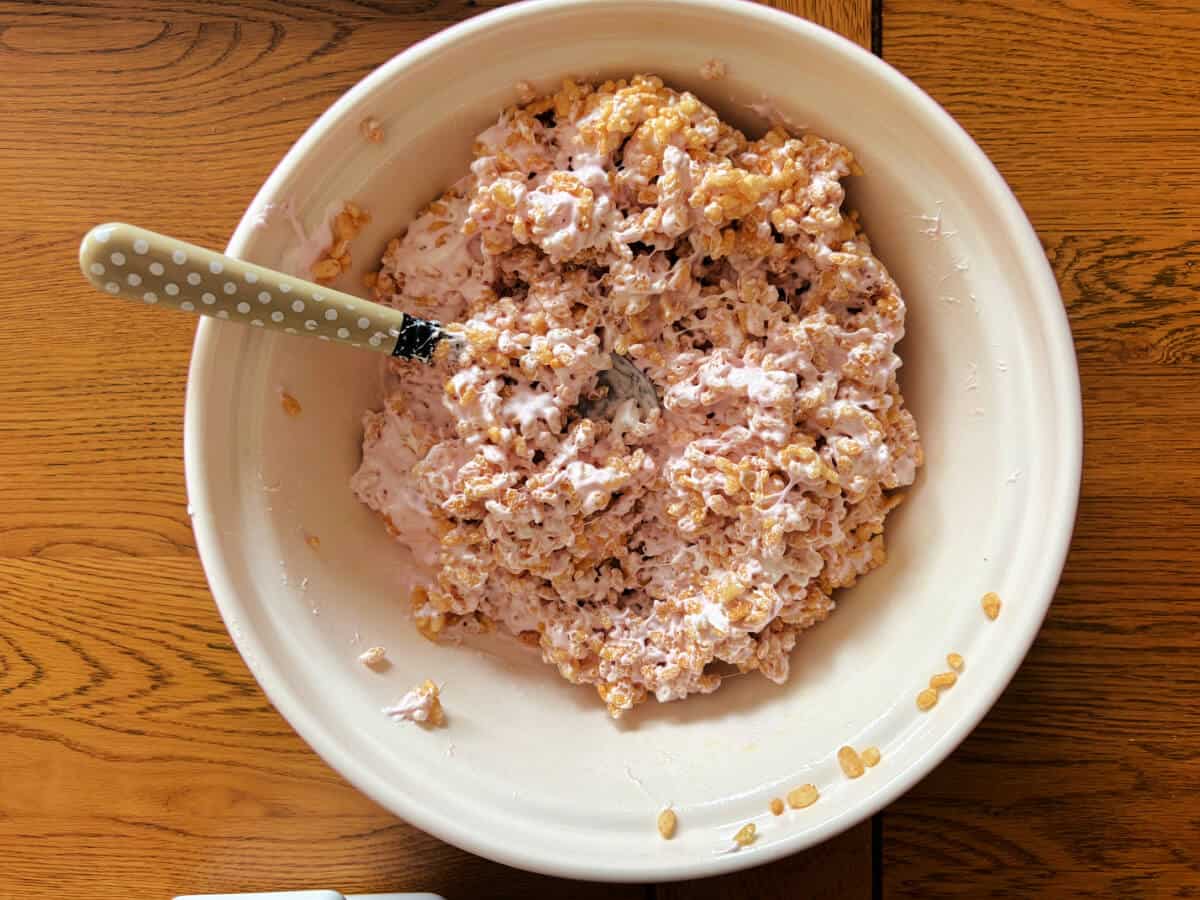 Melted marshmallows and Rice Krispies mixed together, in a bowl.
