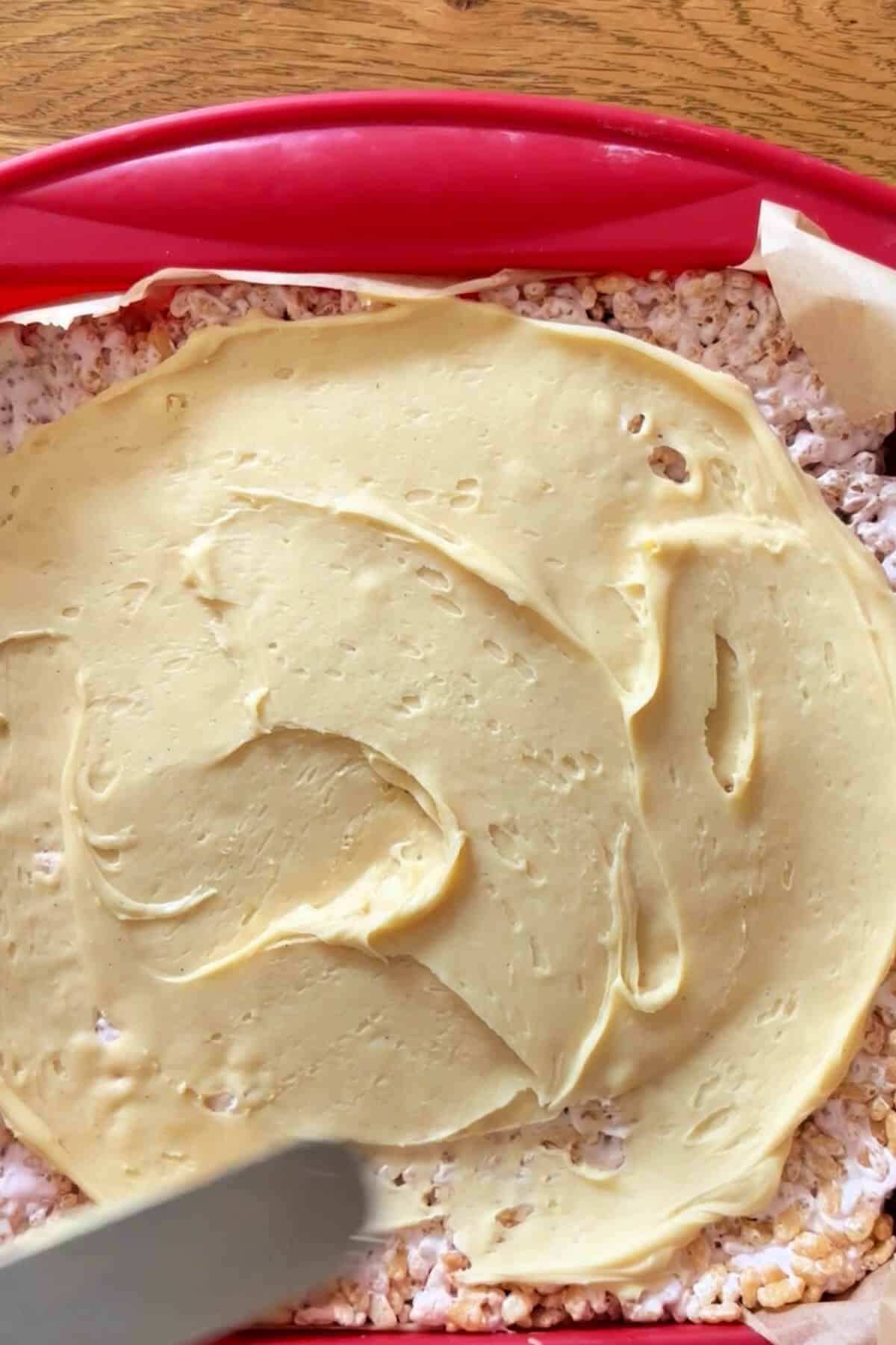Rice Krispie treats topped with white chocolate, in pan.
