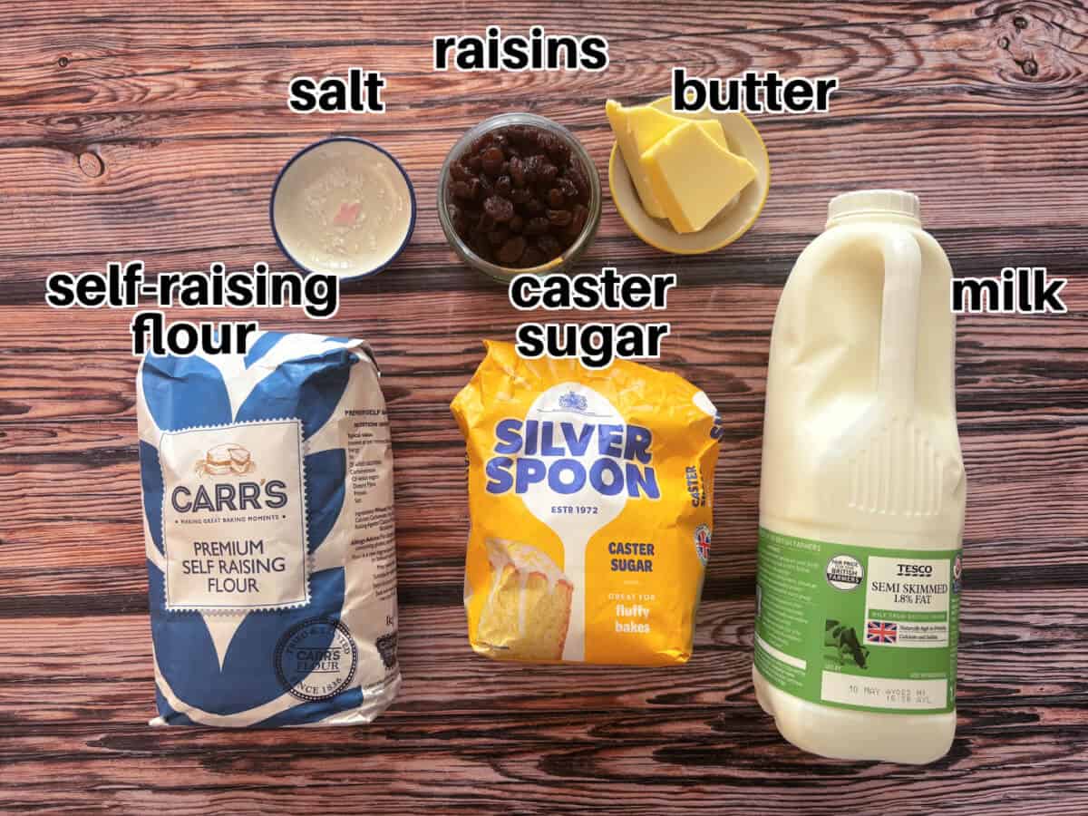 Labelled ingredients for fruit scones on wooden table.
