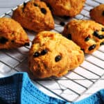 Golden brown triangle fruit scones on a metal cooling rack.