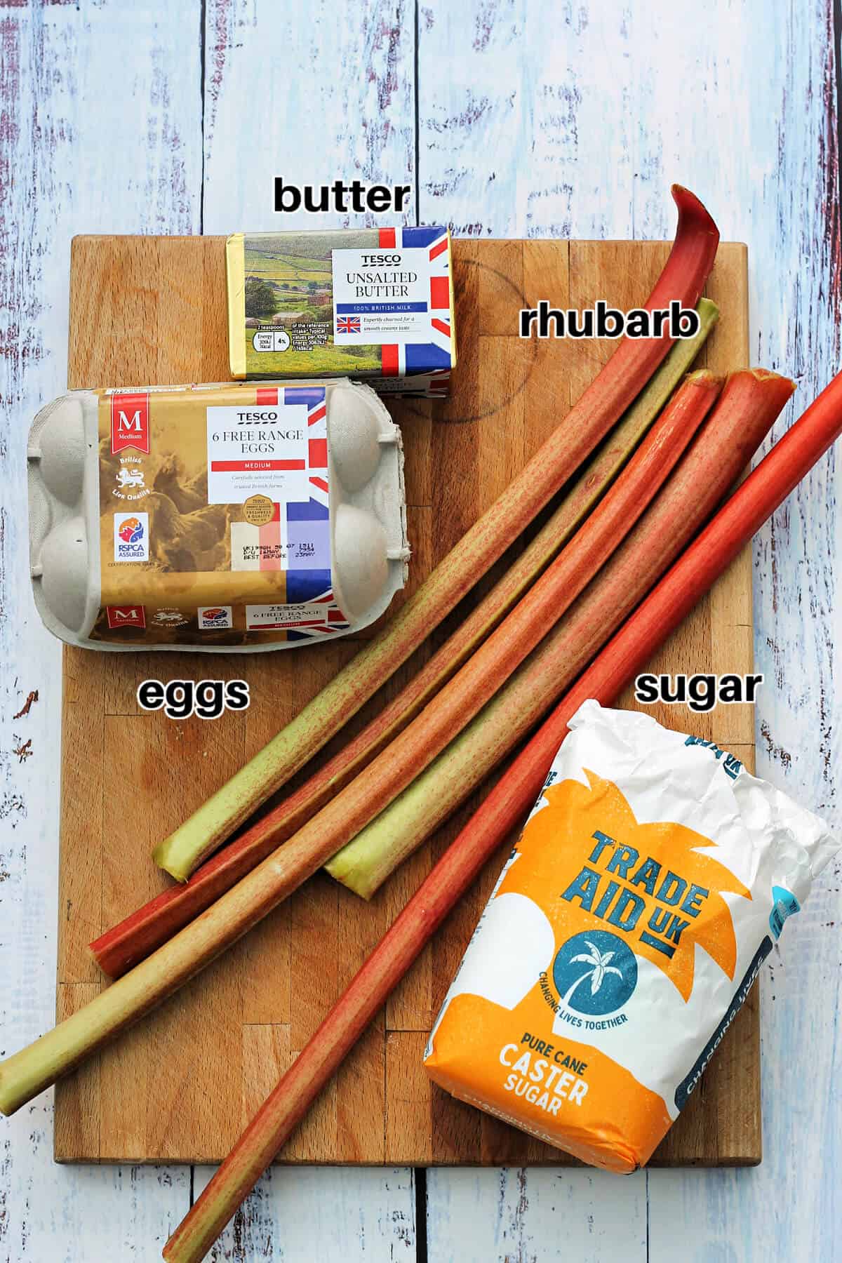 Ingredients for rhubarb curd on a wooden chopping board.