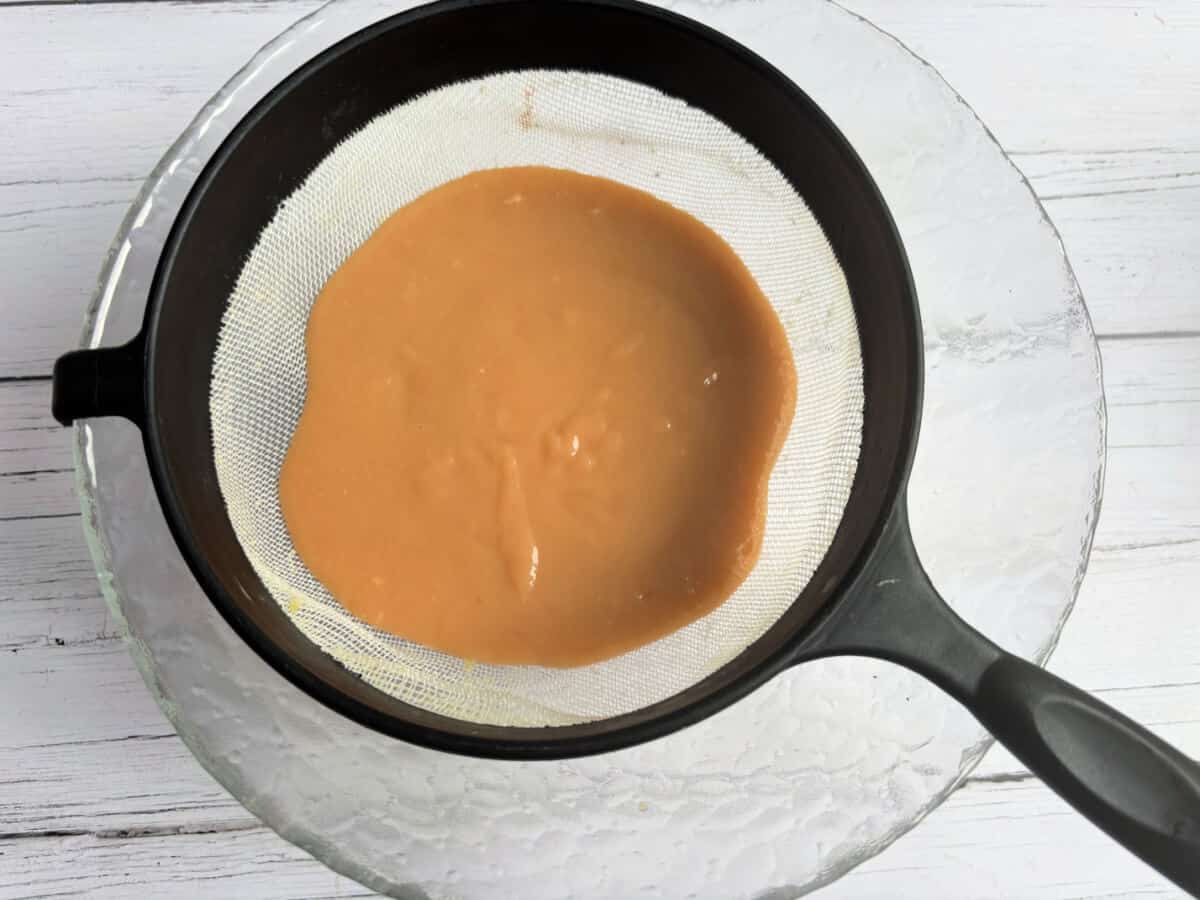 Curd in a sieve over a bowl.